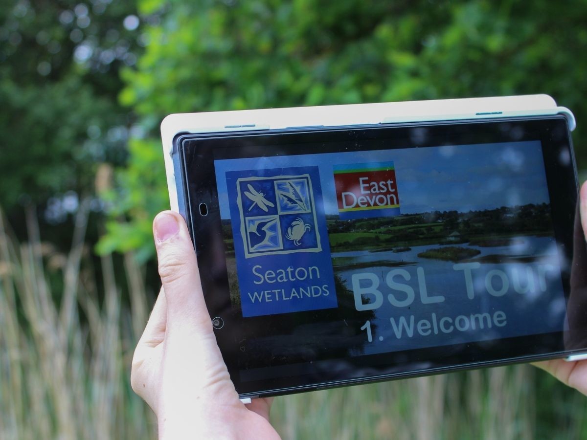 BSL Tour at Seaton Wetlands, image shows BSL tour on tablet, person holding it outside.