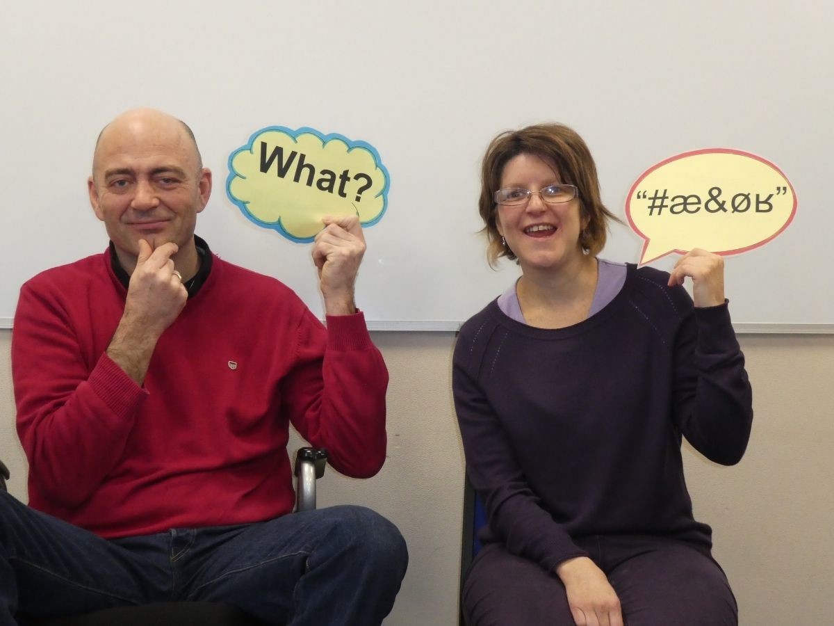 Two people holding up speech bubbles looking confused